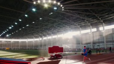 Stadyumda sırıkla atlama - genç adam barın üzerinden atlama