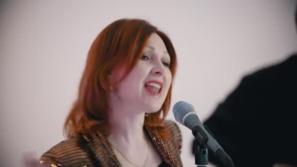 Zenei zenekar játszik egy dalt - gyömbéres nő énekli a szerepét - gitáros játszik a háttérben — Stock videók