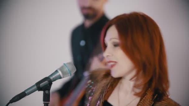 Una band musicale che suona una cover - una donna zenzero che canta con passione e annuisce al bassista — Video Stock