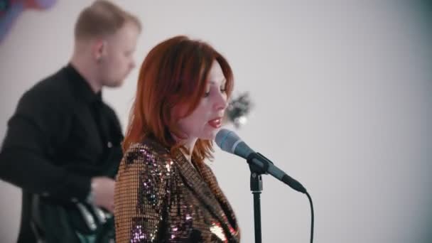 Un groupe de musique jouant une chanson de couverture - femme rousse chantant avec enthousiasme — Video