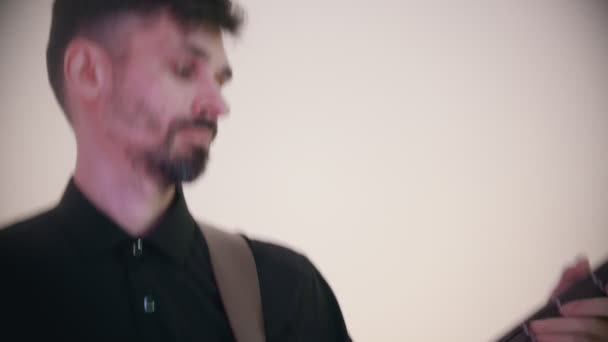 白いスタジオで曲を演奏する音楽バンド-ベースギターを演奏する男 — ストック動画