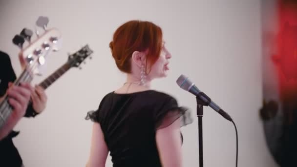 Una banda musical tocando una canción en el estudio - una mujer pelirroja adulta cantando — Vídeos de Stock