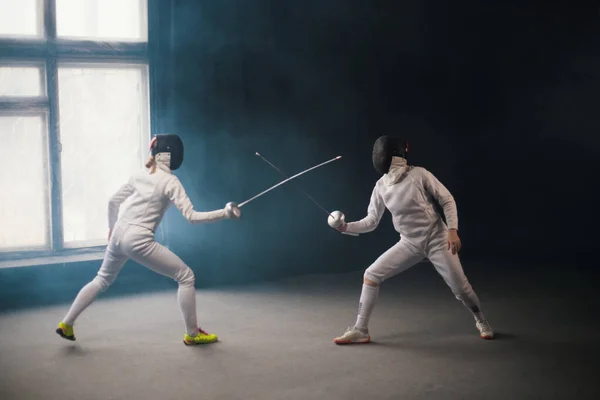 Un entrenamiento de esgrima - dos mujeres en trajes de protección que tienen un duelo — Foto de Stock