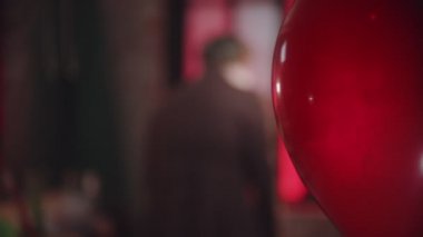 Kırmızı bir balon geçiyor. Ürkütücü bir palyaço elinde korkunç bir gülümsemeyle elinde bir balonla dönüyor.