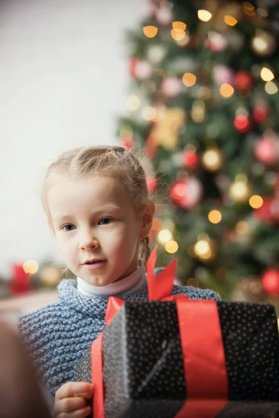 Concepto de Navidad - una niña pequeña sosteniendo un regalo — Foto de Stock