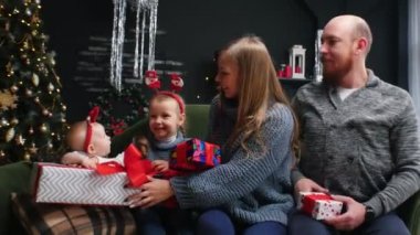 Yeni yıl - aile hediyelerine bakar ve gülümser.