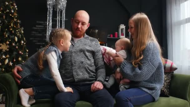 Año Nuevo - papá está abrazando a sus hijos y esposa en el sofá — Vídeos de Stock