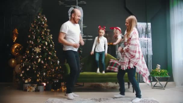 Nieuwjaar - mama en papa dansen met hun kinderen bij de kerstboom — Stockvideo