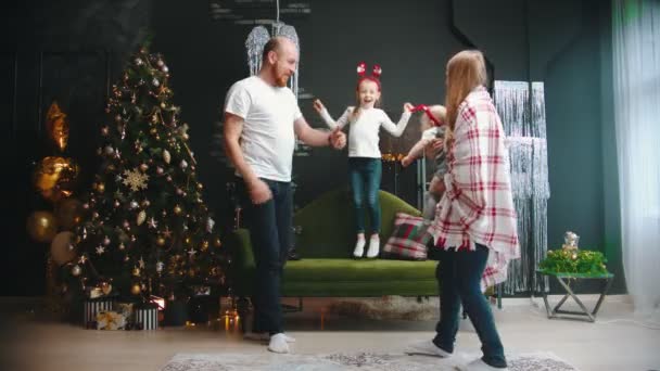 NEW YEAR - сім'я розважається в залі поруч з ялинкою — стокове відео