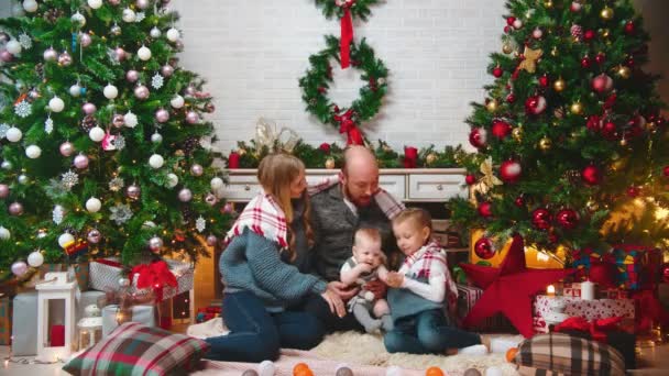 AÑO NUEVO - familia sentada junta bajo una manta y comunicándose — Vídeo de stock