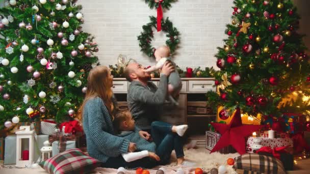 AÑO NUEVO papá está lanzando al bebé en el aire y la captura de varias veces — Vídeo de stock