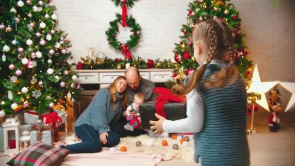 NOVO ANO - filha está correndo até seus pais e dando-lhes um presente — Vídeo de Stock
