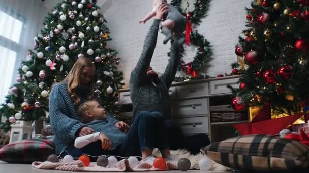 Nový rok - táta vyhazuje dítě do vzduchu v blízkosti rodiny - zpomalený film — Stock video
