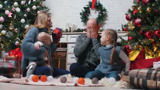 Año Nuevo - mamá le está dando a papá un regalo y besándolo — Vídeo de stock