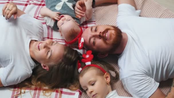 Ano Novo - a família está deitada em um cobertor falando e sorrindo — Vídeo de Stock