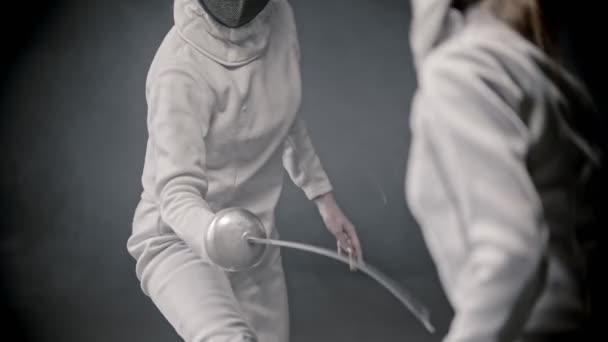 Обучение фехтованию - две молодые женщины в защитной одежде, имеющие поединок между собой — стоковое видео