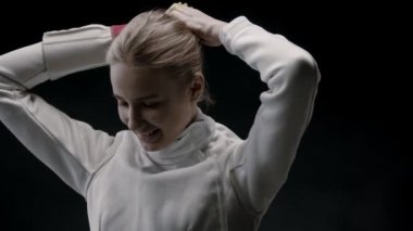 Genç bir eskrimci kadın antrenmandan önce saçlarını topuz yapmış.