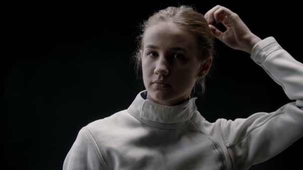 A young pretty woman fencer lets her hair down — ストック動画