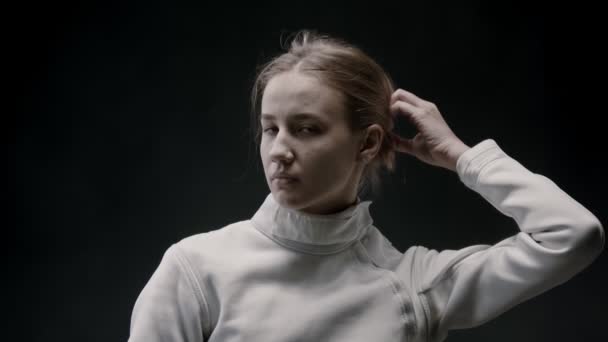 A young woman fencer lets her hair down — ストック動画