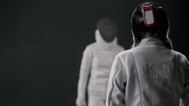 Vívógyakorlat a füstös stúdióban - két fehér öltönyös nő párbajozik — Stock videók