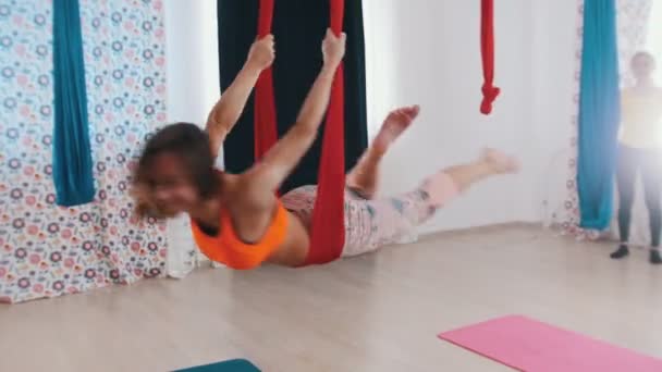 Hava yogası. Hamakta yoga yapmak ve eğlenmek için asılı bir atletik kadın. — Stok video