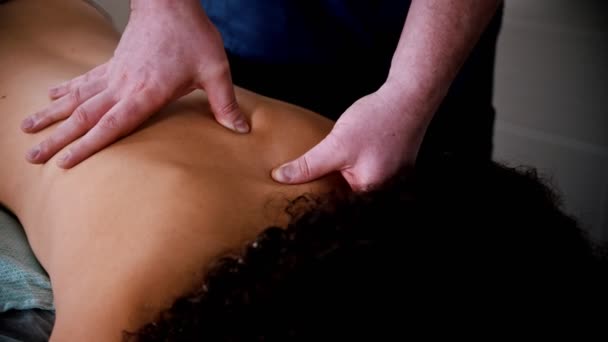 Chiropraktická léčba - lékař dává pacientovi jemnou špičatou masáž zad — Stock video