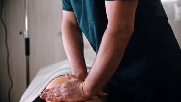 Tratamento quiroprático - o médico que dá ao paciente uma massagem - pressionando as costas com as mãos — Vídeo de Stock