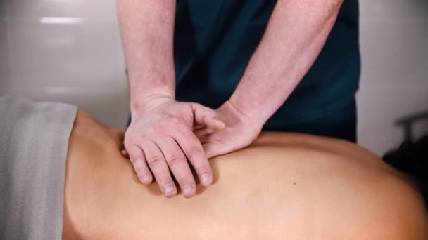 Chiropractic treatment - the doctor giving the patient a massage - softly pushing down on the back with hands — Stock Video