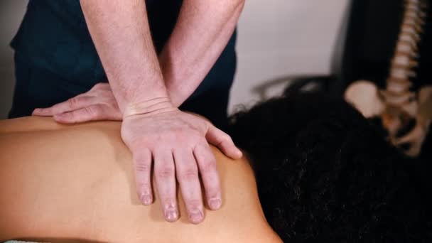 Kayropraktik tedavi - doktor bir kadına omurga için masaj yapıyor - kürek kemiklerine bastırıyor — Stok video