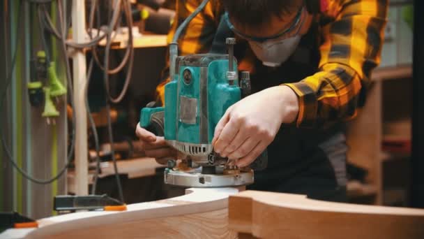 La carpintería en el interior - el carpintero de hombre pule la esquina de la parte de madera de los muebles — Vídeos de Stock