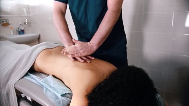 Chiropractic treatment - the doctor giving the patient a massage - pushing down on the back with hands — Stock Video