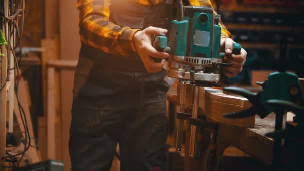 Zimmerei drinnen - ein Holzarbeiter setzt eine Poliermaschine auf das Detail, um die Seiten zu polieren — Stockvideo