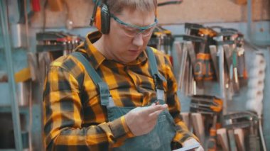 Carpentry indoors - a man woodworker pulls out a pencil and making marks on the wooden detail