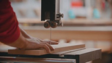 Kapalı alanda marangozluk - bir marangoz ahşap bir bloğun düzenini keser - arka planda çalışan başka bir adam