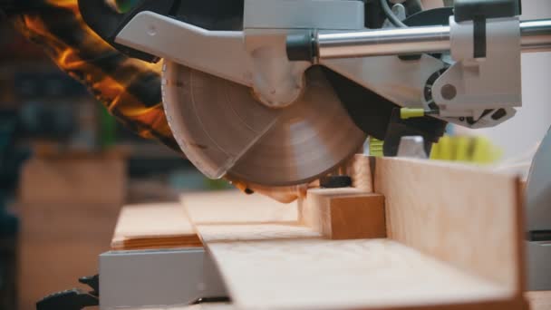 Timmerwerk - een houtbewerker die het houten detail snijdt met een cirkelzaag — Stockvideo