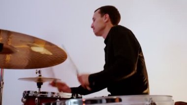 Müzik grubundan mutlu bir baterist stüdyoda şarkı söylüyor.