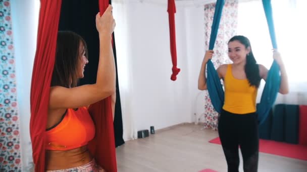 Légi jóga - Két nő ül függőágyban és beszélgetnek egymással — Stock videók