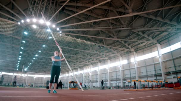 ポール・ボールト-スポーツ女性は長いポールを取って走り — ストック動画