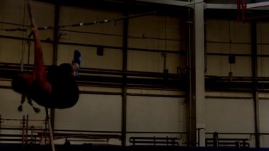 Sırıkla atlama - genç sporcu kadın barın üzerinden atlıyor