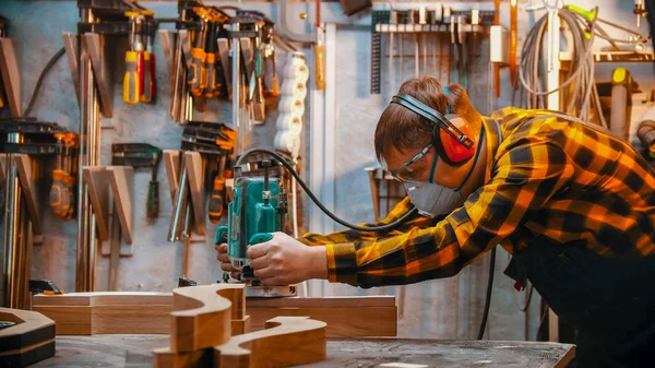 Falegnameria al chiuso - un falegname lucida il dettaglio in legno in officina — Foto Stock