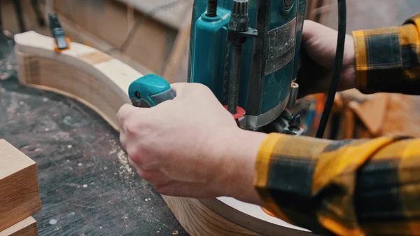 Carpintería interior: un carpintero pule el detalle de madera desde la parte superior del taller — Foto de Stock