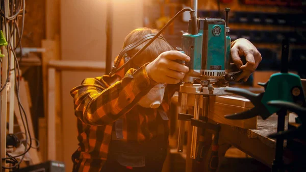 Carpintería interior: un carpintero hombre que fija una máquina de pulir en el detalle — Foto de Stock