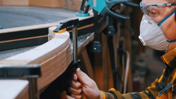 Столяр - працівник з дерева, що вимірює ширину дерев'яних деталей — стокове фото