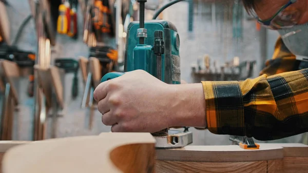 Carpintaria dentro de casa - um marceneiro polir o detalhe de madeira na oficina — Fotografia de Stock