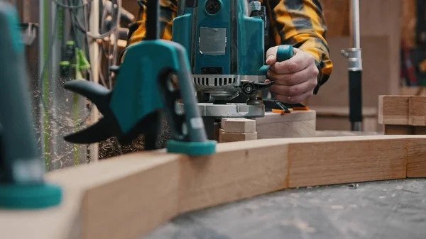 Trabajos de carpintería en interiores: un carpintero pule el detalle de madera desde la parte superior del taller — Foto de Stock