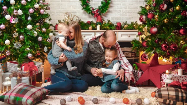 Ευτυχισμένη επιτυχημένη οικογένεια κάθεται στο Χριστουγεννιάτικο σκηνικό — Φωτογραφία Αρχείου