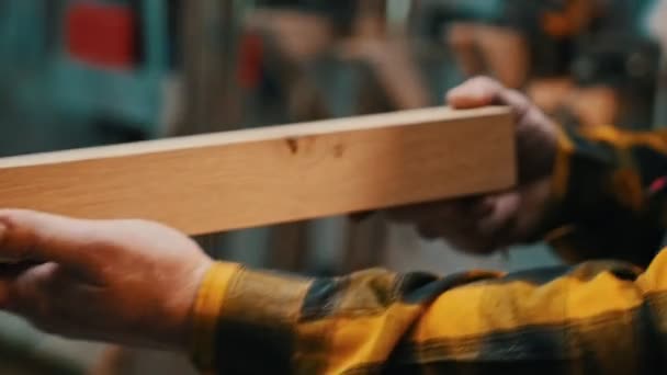 Столярная промышленность - человек деревообработчик осматривает измельченные детали на предмет недостатков — стоковое видео