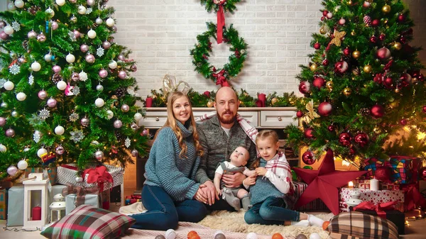 Χριστούγεννα έννοια - ευτυχισμένη επιτυχημένη οικογένεια κάθεται στο σκηνικό των Χριστουγέννων — Φωτογραφία Αρχείου