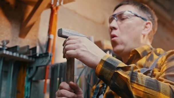 Carpentry industry - a man woodworker blowing off dust from the hammer — ストック動画