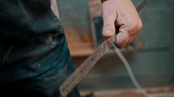 Столярна промисловість - працівник деревини, що вимірює дерев'яний шматок з двориком — стокове відео